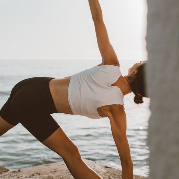 Person stretching calmly outdoors at sunrise.
